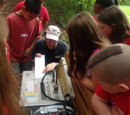 Fourth-grade students examine seismograms for an "earthquake" they have generated during an outdoor Environmental Field Day event at the Georgia Mountain Research & Education Center (GMREC) near Blairsville, GA. (Image from Peggy Schneider, GMREC Community Council)