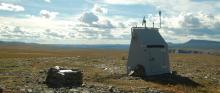 The Dempster Highway winds southward in the distance from station TA.G30M, situated north of the Arctic Circle.