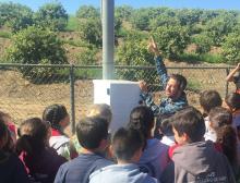 Students learn firsthand, from UNAVCO field engineer Ryan Turner, how the GPS station at Olivelands Elementary School measures ground movement. The lesson includes discussing why monitoring plate movement is important for the students’ community. (Photo by Beth Bartel, UNAVCO)